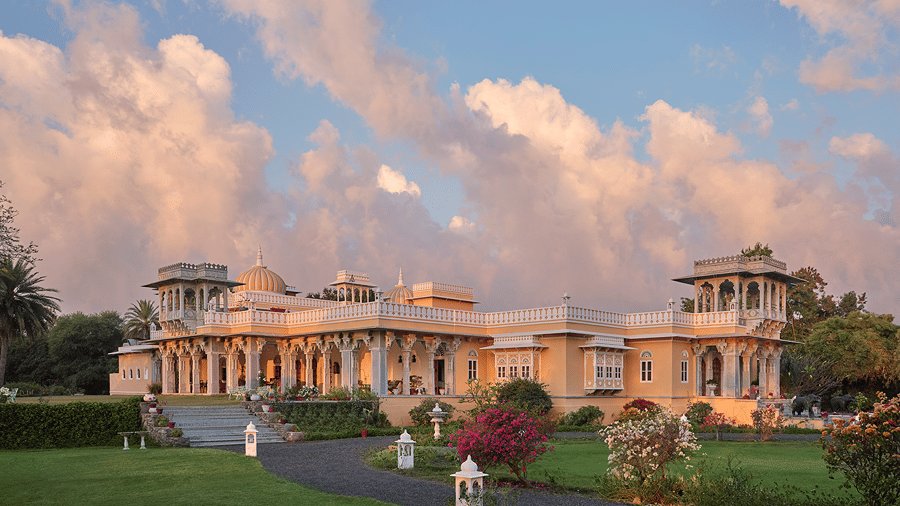 Dev Shree, Deogarh facade set against a picturesque sky with clouds in the background.