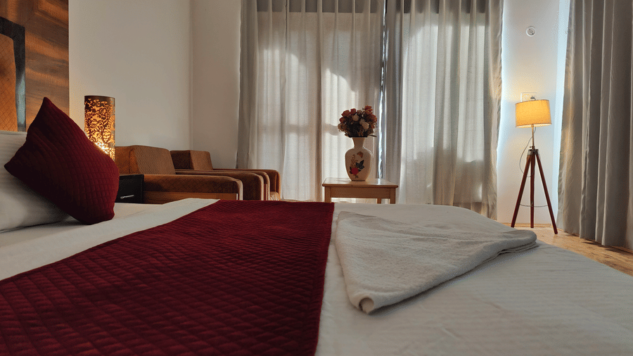 A cosy corner of a  bedroom featuring comfortable armchairs and soft bedside lighting at Indus Serenity Retreat.claudio-mota-wHzJmHtbqvA-unsplash