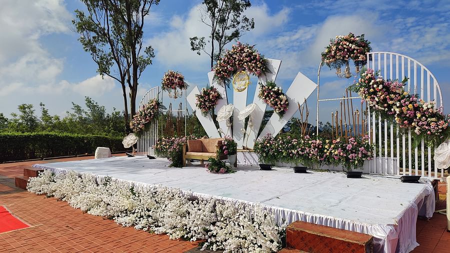 Decorated outdoor wedding stage with flowers and white linens | Open Deck