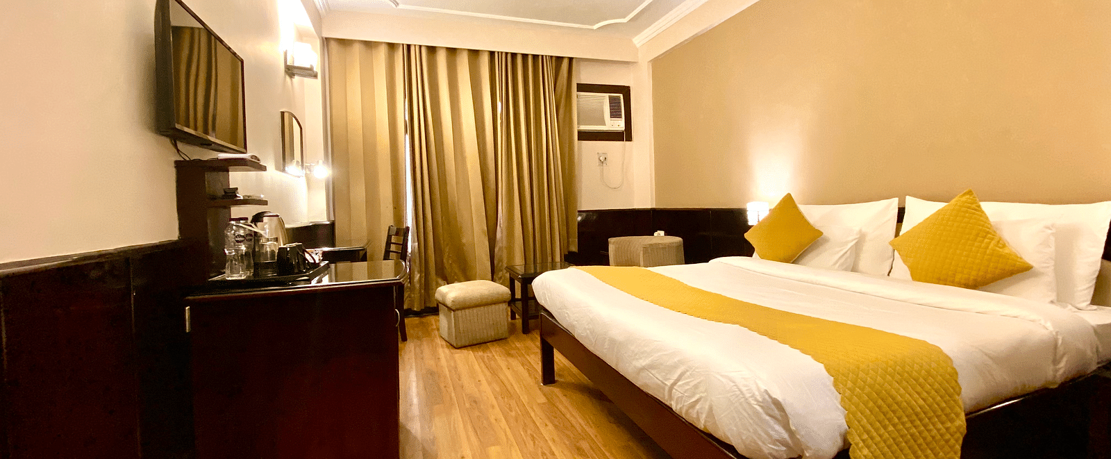 Side view of a bedroom with a wall-mounted television at DLS Park Grace, Haridwar.