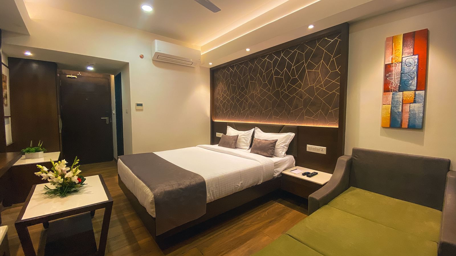 a bedroom with a large bed and a table - Jardin Hotels, Indore
