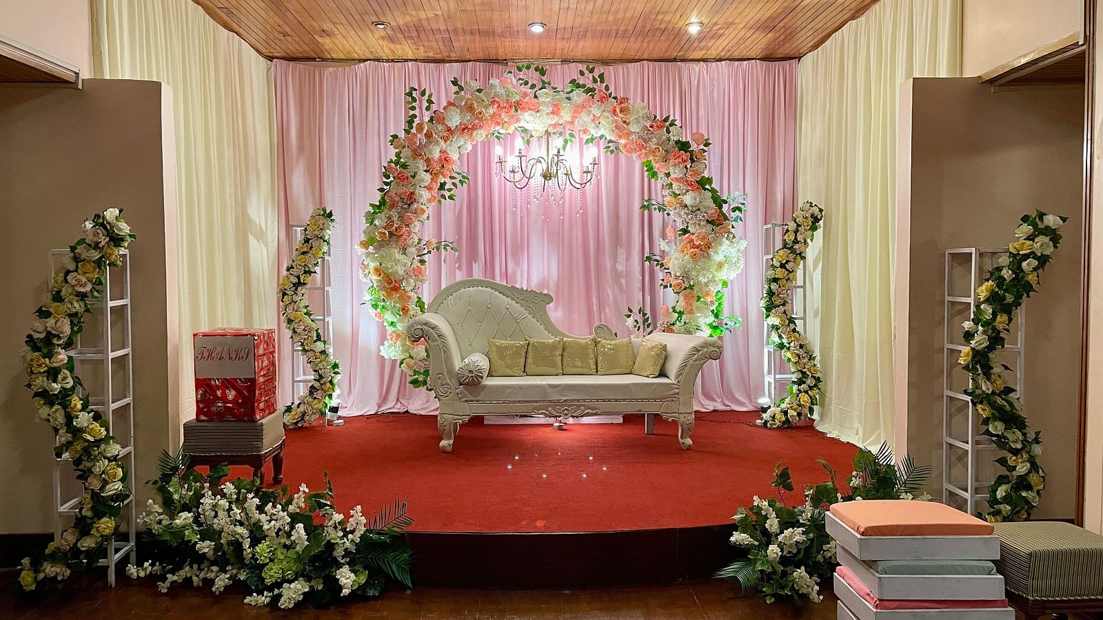 Indoor wedding stage setup at Cedar Inn, Darjeeling, with floral arch, stage seating, and draped backdrop for ceremonies.