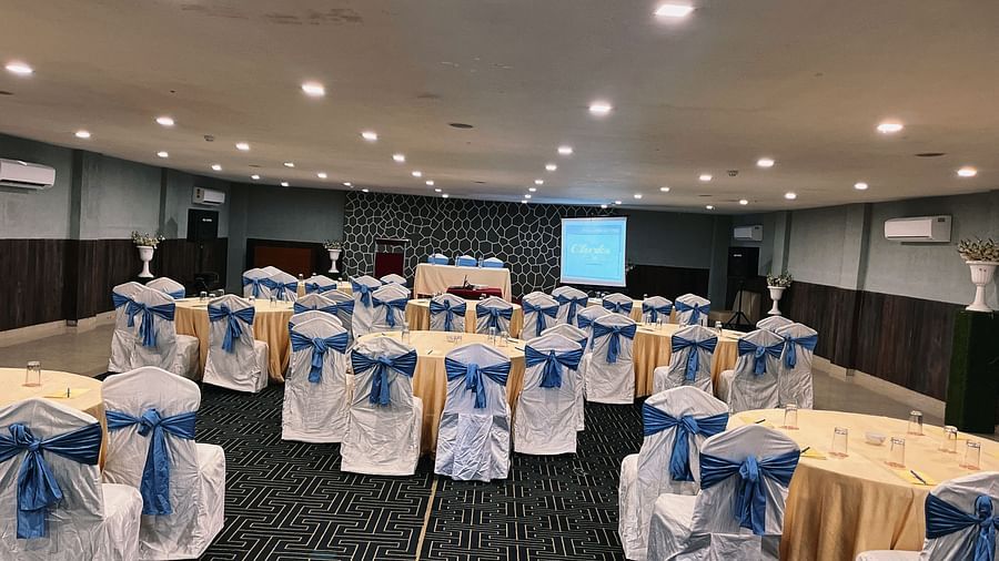 The banquet hall is set up with round seating tables at Clarks Collection, Bhavnagar