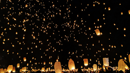 A group of people releasing sky lanterns into the night sky