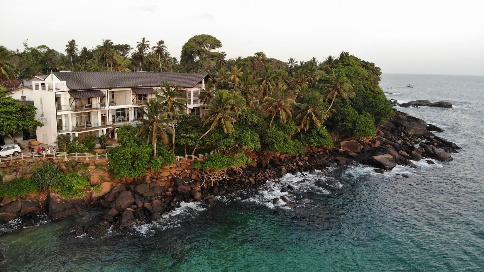 aerial view of the beacon by the bay villas and suites amidst lush tropical greenery with crystal clear peninsula in dondra