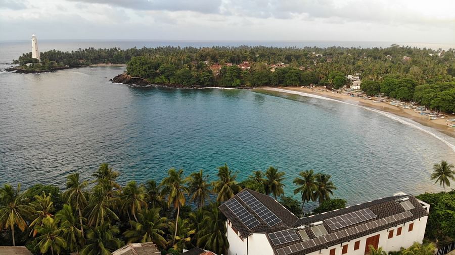 an aerial image of the ocean spread across with the golden coastline 