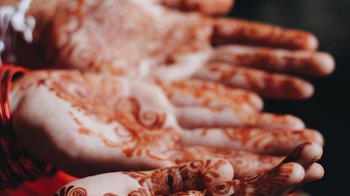 A close up shot of two henna stained hands