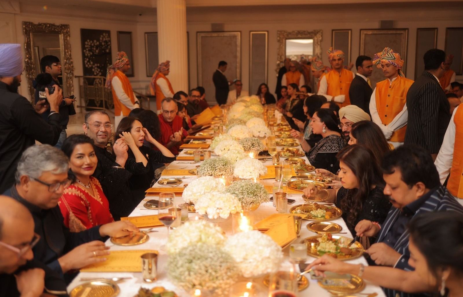 Guests enjoying their meal at the Royal Gala Dinner, seated at a large table beautifully decorated with flower bouquets and served food