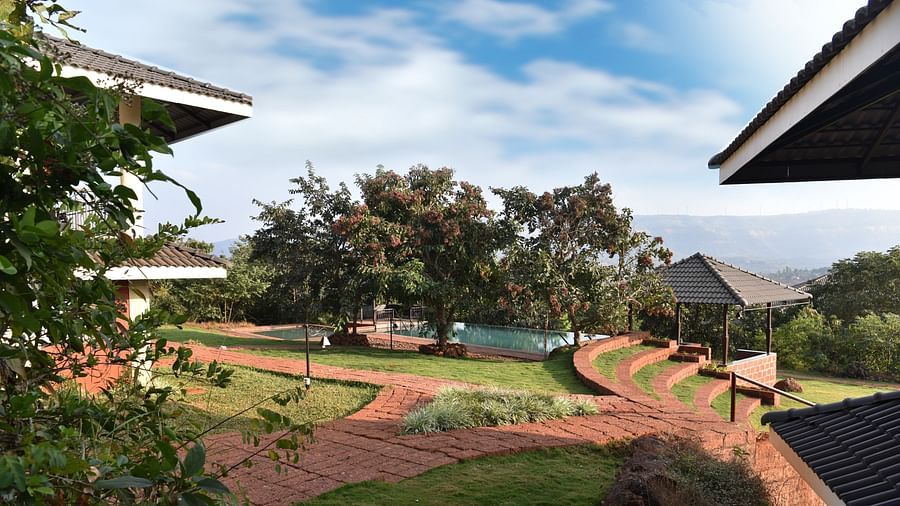 Captured at Forest Escape, this image offers a wider view of the resort grounds with gardens and trees under a partly cloudy sky.