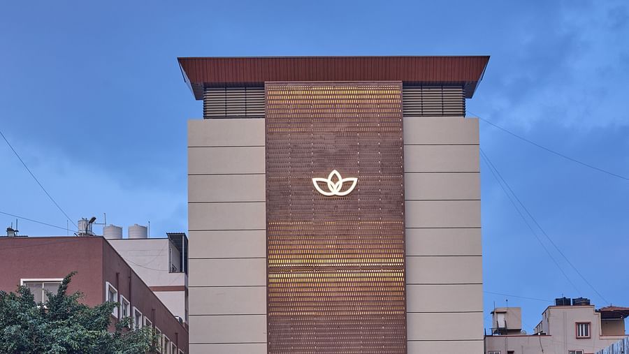 An evening view of our hotel facade with our hotel logo illuminated by warm yellow lights - Grand Continent, Brookefield