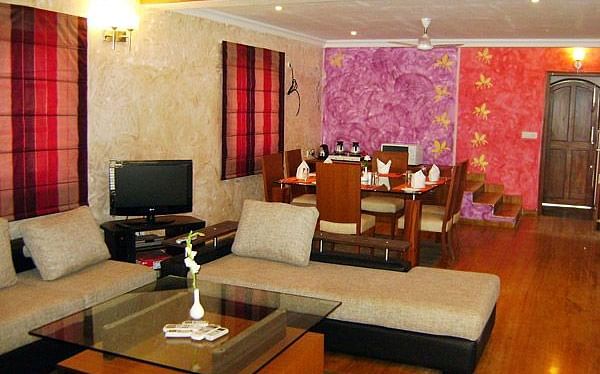 Living area featuring sofa placed around a coffee table with a six-seater dining table in the background