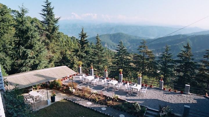 Aerial view of a resort complex with outdoor seating and a swimming pool.