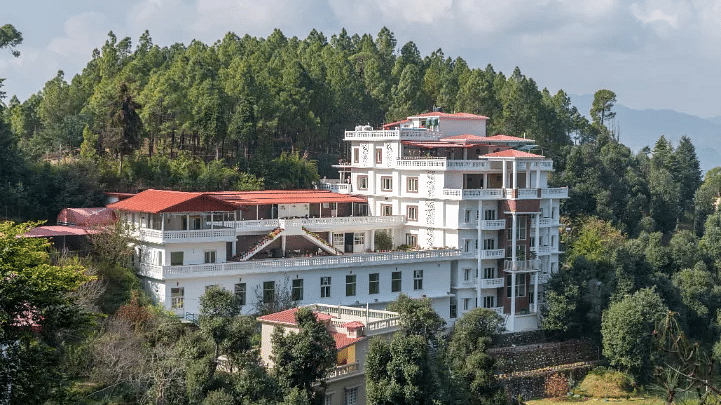 exterior image of a hotel complex nestled amidst lush greenery on a bright sunny day
