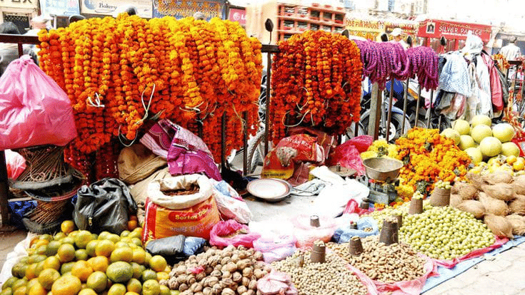 Vibrant street market stalls filled with fresh orange marigold flower garlands and fruits for the Tihar festival in Bhaktapur, Nepal.