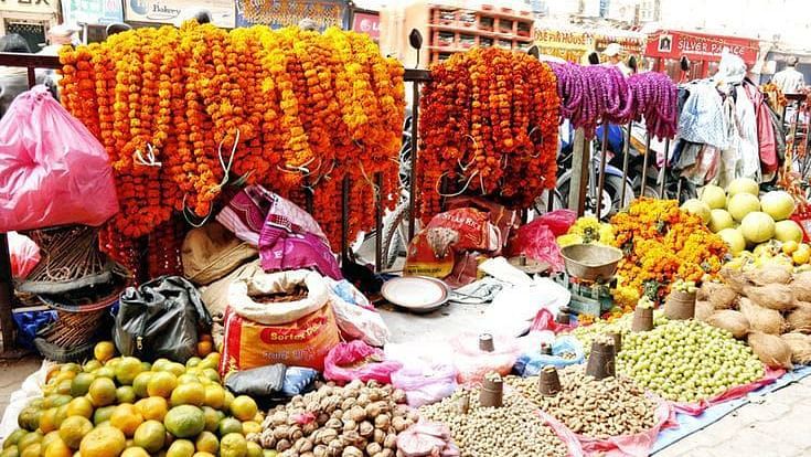 A small roadside shop selling flower garlands, fruits and more