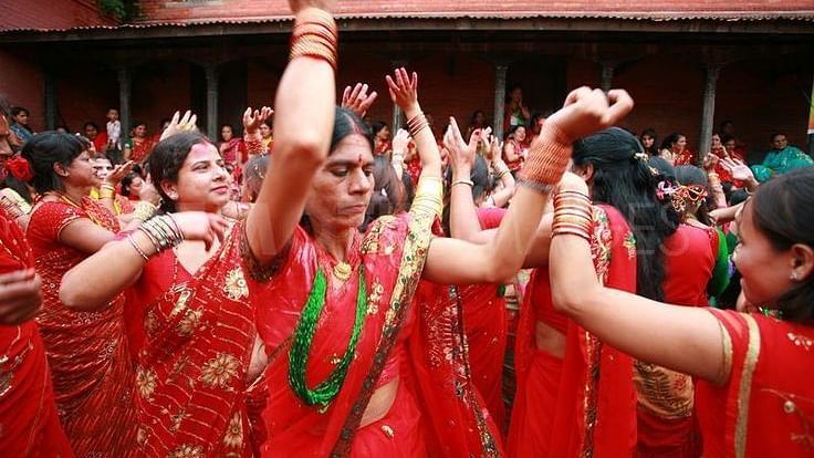 A group of women dancing wearing red saree