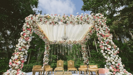 Wedding mandap structure with floral arch and chairs at Vinti Resort, Ambaji.