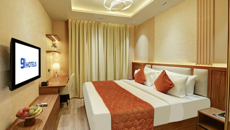 Full view of the Standard Room at Hotel 91 Privé, Gurugram, featuring a double bed and a modern light fixture hanging from the ceiling above at Hotel 91 City Centre, Gurugram.