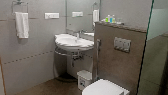 A modern bathroom with sleek fittings, a clean aesthetic, and essential amenities. - Abad Brookside Lakkidi, Wayanad