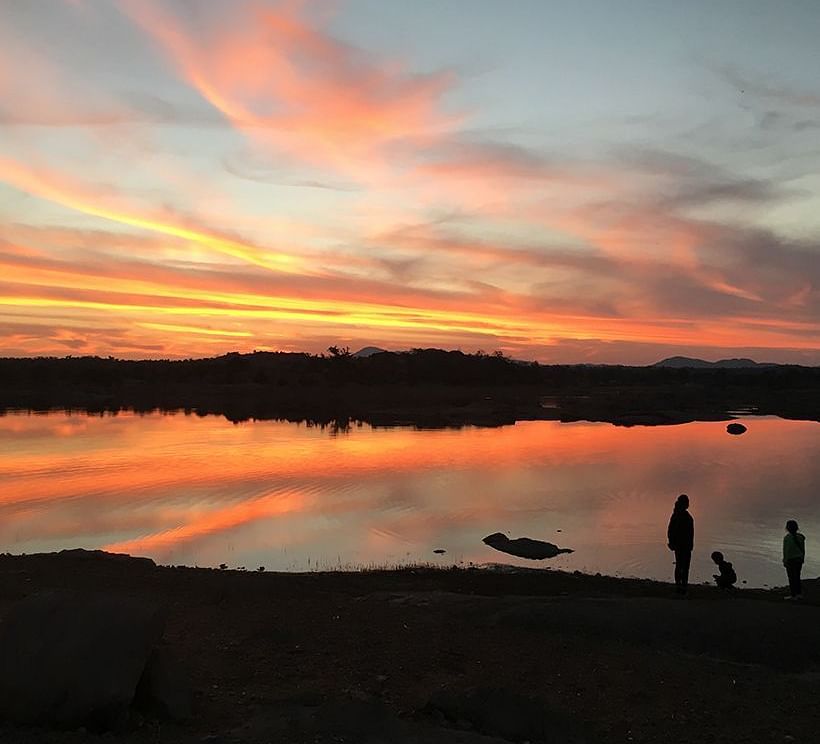 image of people along side the lake and soaking in the Sunset at dev shree, deogarh