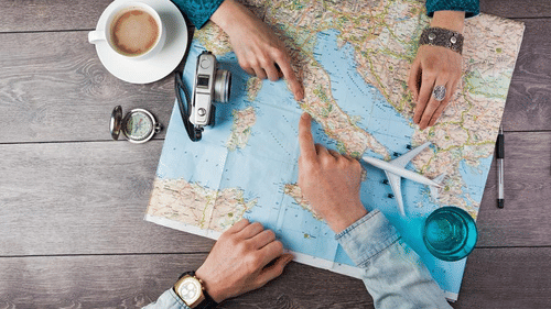 two persons pointing to a place on the map