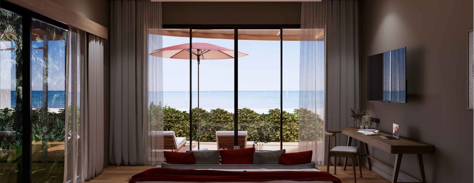 A bedroom with large glass doors opening to a private patio, red umbrella, sunbeds, and stunning ocean view at Ramada Resort by Wyndham Khao Lak.
