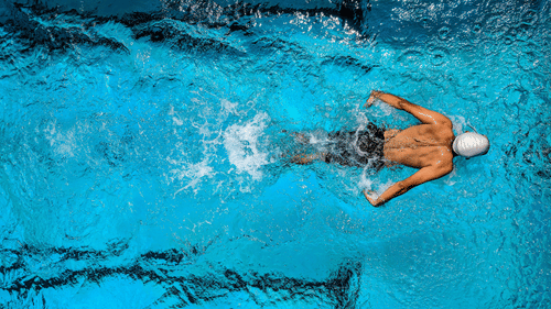 An aerial view of a man swimming in a pool