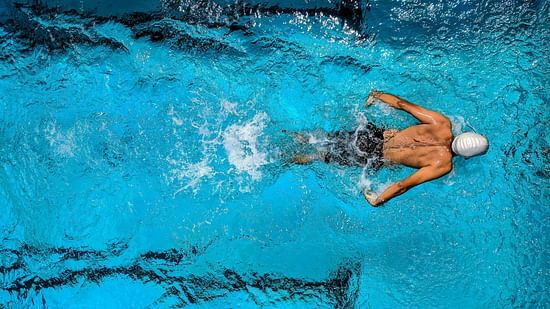 An aerial view of a man swimming in a pool