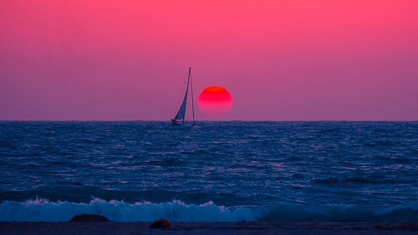 A wide shot of a sea with a backdrop of sunset