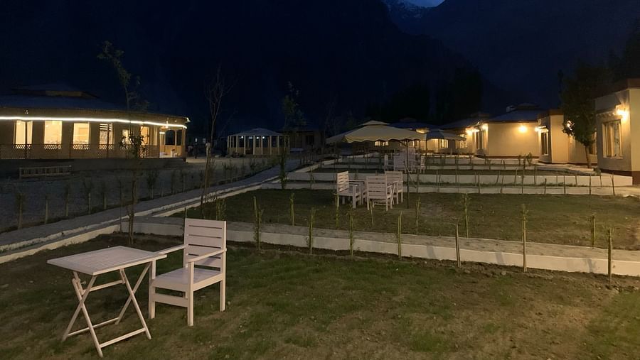 Nighttime view of White Sand Resort, Ladakh with illuminated cabins and mountains in the background.