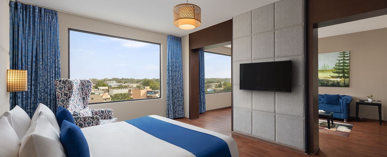 Dleuxe Suite at Essentia Luxury Hotel, Indore with a double bed, a television and a separate living area
