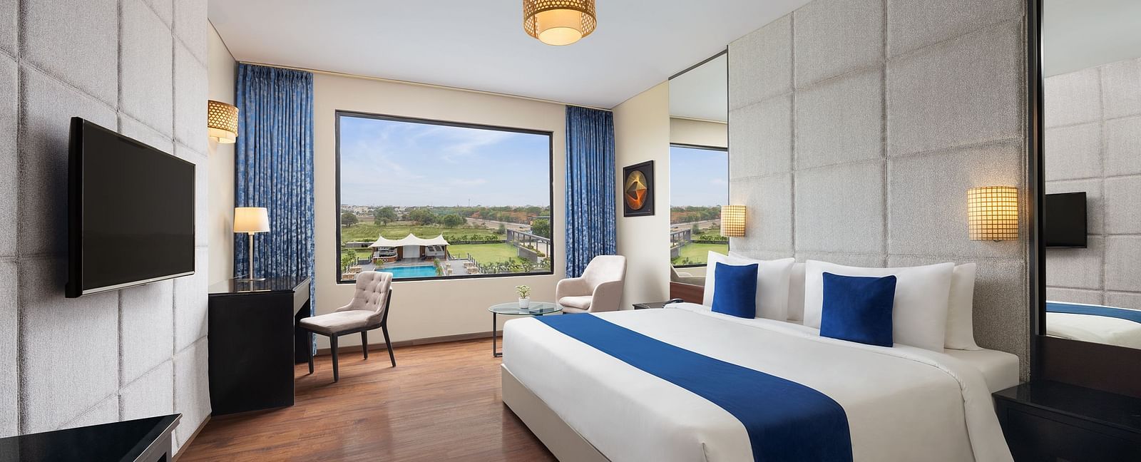 Premium Room at Essentia Luxury Hotel, Indore with a double bed, a television and work desk and chair