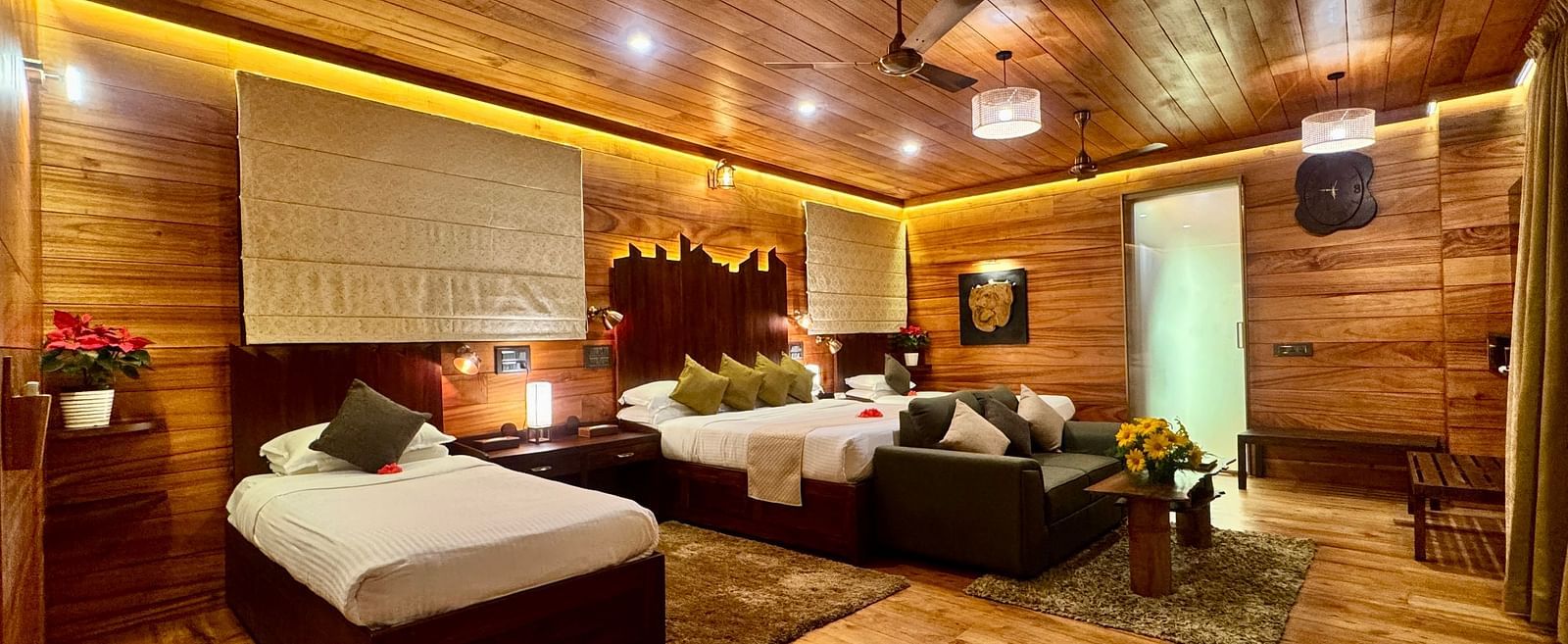 Wood-panelled interior of a room with a seating area and soft warm lighting - BluSalzz Collection - Tranquil Resort, Wayanad