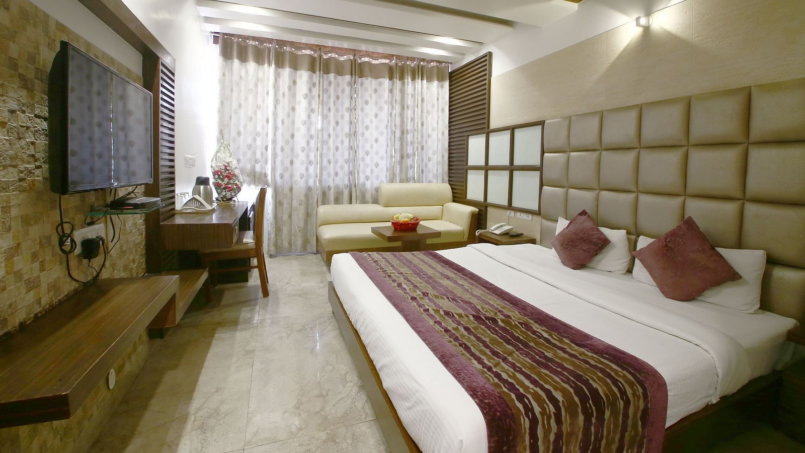 Another view of the same hotel room, showcasing the stylish decor, curtains, and plush bedding - Hotel Emerald, Chandigarh