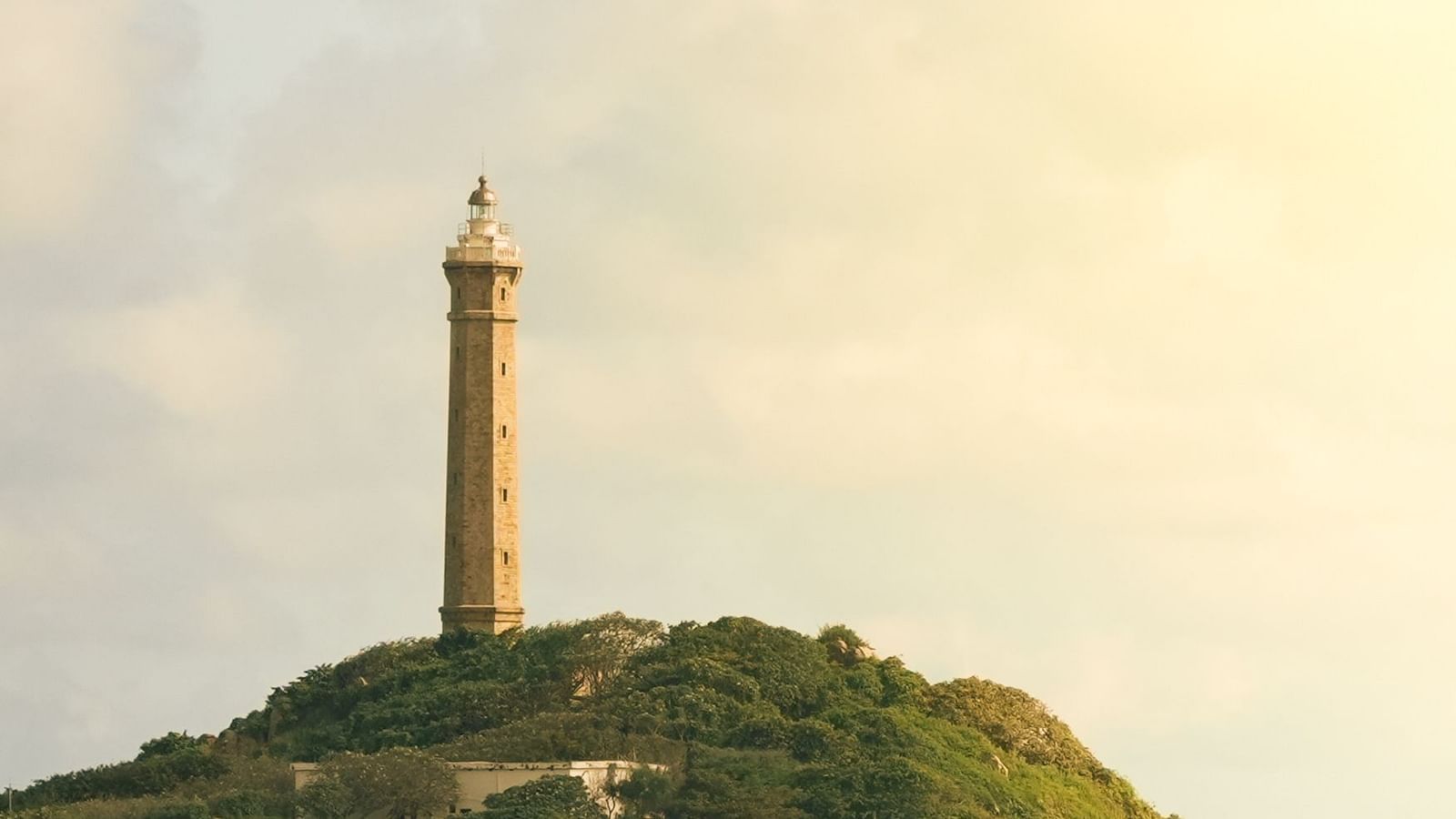 An overview of Ke Ga Lighthouse on Hon Ba Island with white clouds in the sky.