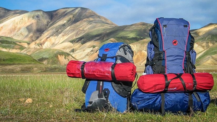 backpacks resting on grass with hills in the background