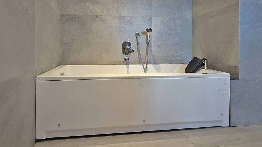 Bathroom featuring a freestanding bathtub, tiled walls, and fixtures