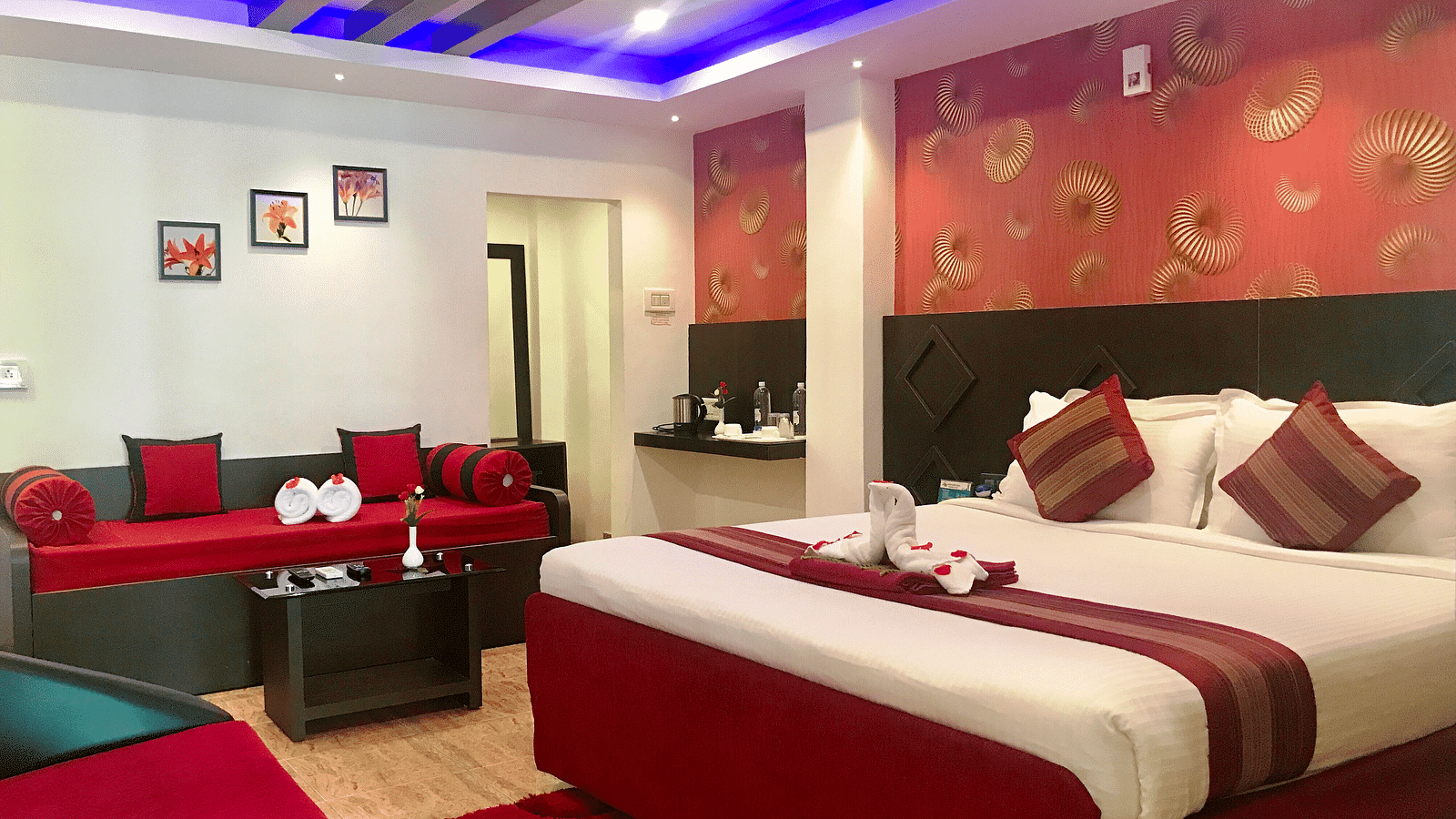 A room with a bed decorated with towels and flower petals at Parampara Resort & Spa, Kushalnagar.