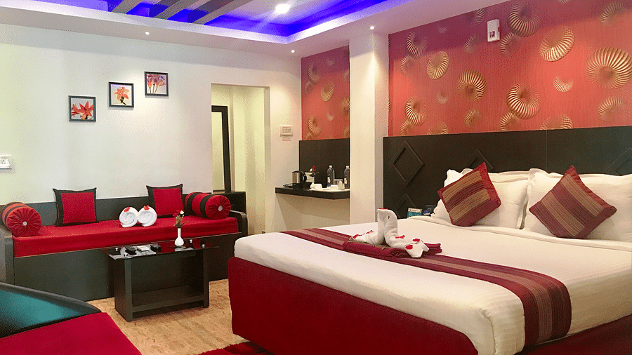 A room with a bed decorated with towels and flower petals at Parampara Resort & Spa, Kushalnagar.