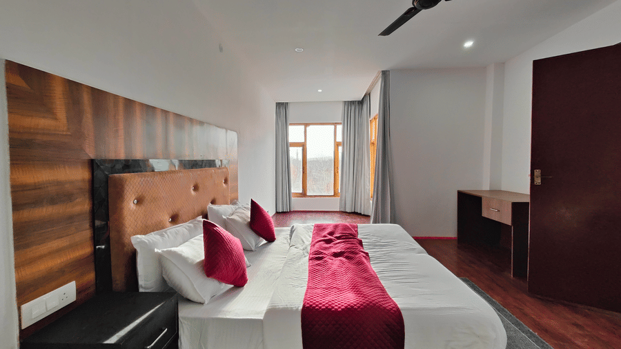 A long-view of a modern and spacious room with clean white walls and wooden accents at Indus Serenity Retreat.