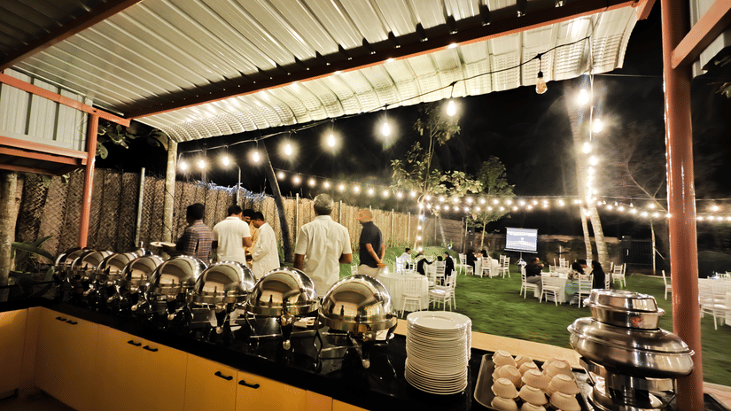 Outdoor buffet setup for a destination wedding at Ibex Resorts, Coimbatore (Kakarla), with elegant dining arrangements under ambient lighting.