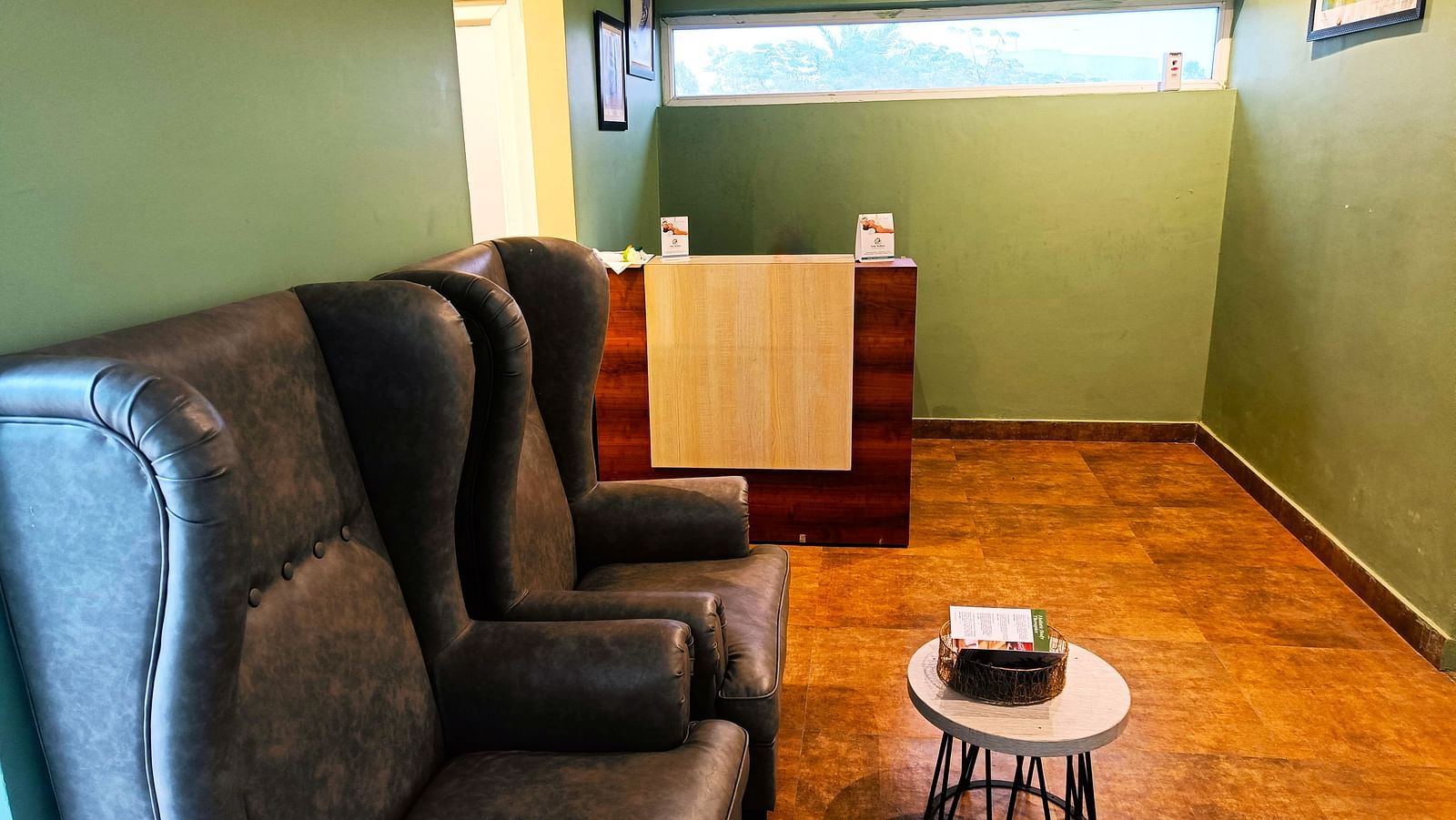 Spa reception area at DLS Forest Vines Resort featuring cushioned seating, a small sound table, and a reception desk in the corner.