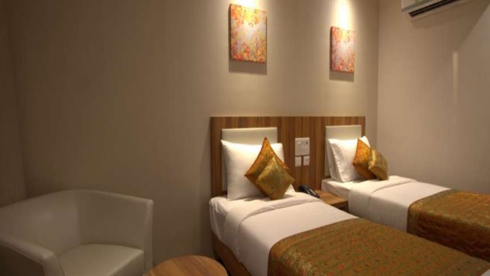 deluxe room with twin beds captured from different angles that showcase the in-room amenities and interior of the bedroom - le roi raipur hotel2