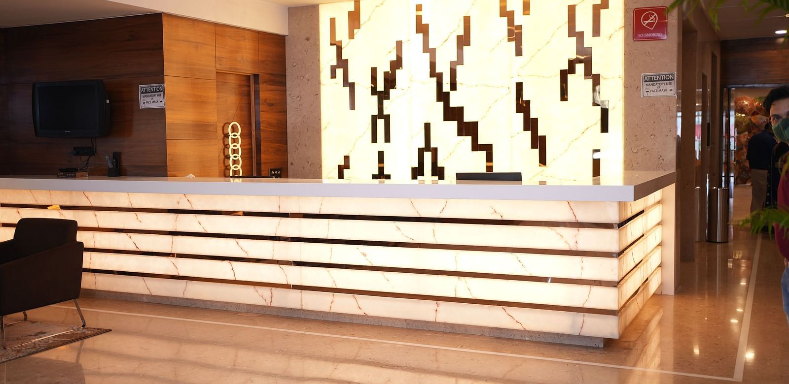 Stylish reception desk at Rang Lords Inn, featuring decorative wall art and warm lighting, welcoming guests to the hotel