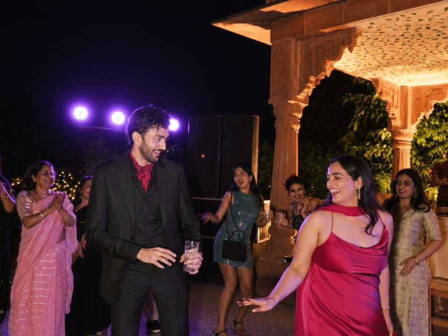 Guests dancing and celebrating on an outdoor courtyard floor during an evening event at Umaid Palace.