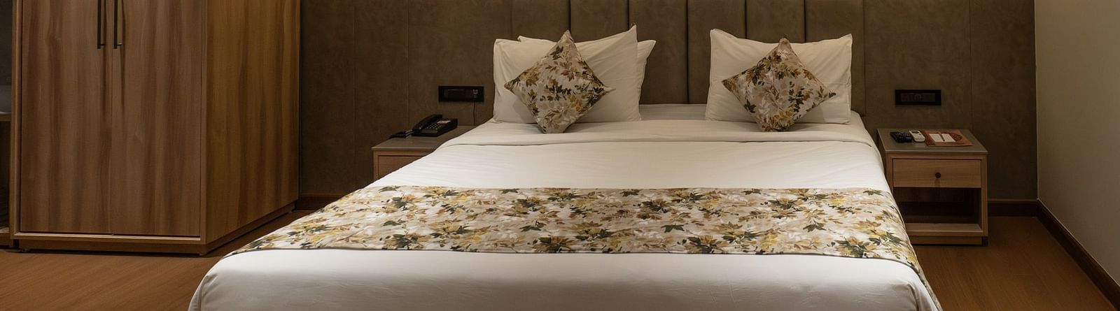 a double bed with lamps above and a wardrobe inside the suite - The Cindrella Hotel, Siliguri