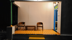 A circular outdoor seating area with a small table and chairs under a clear, domed roof