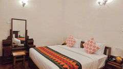 An overview of the Whitehall room with a king size bed, a dressing table along with other amenities - Ibex Resort, Coonoor (Leewood).