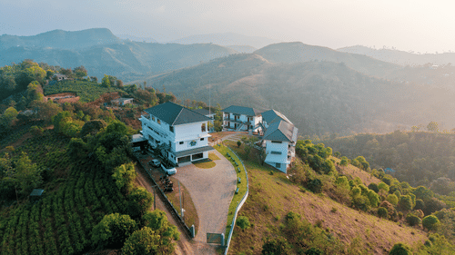 An aerial view of the one of the best family resorts in Vagamon, on a grassy hilltop surrounded by tea plantations and rolling mountains at Abad Silvermist, Vagamon.
