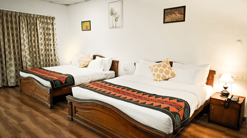 Twin bed deluxe room with wooden flooring at Ibex Resorts, the best accommodation in Valparai.